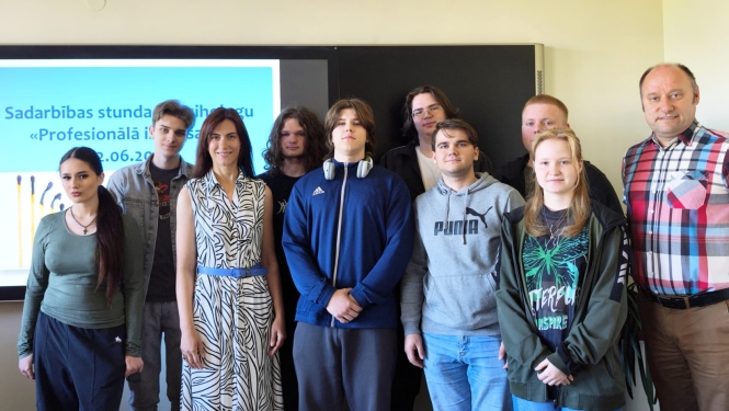 Kopbildē redzami izglītojamie un pedagogi pie interaktīvās tāfeles