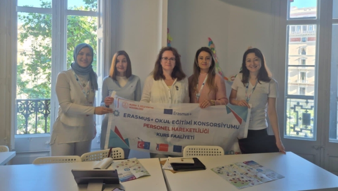 Piecas Erasmus+ kursu dalībnieces pozē grupas foto ar projekta baneri