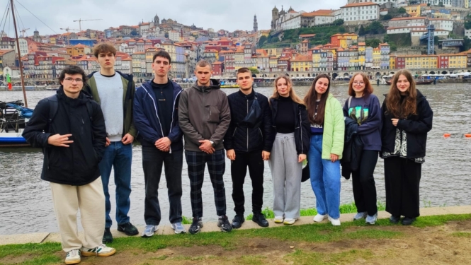     Izglītojamo grupa pozē Douru upes krastā ar Porto panorāmu fonā