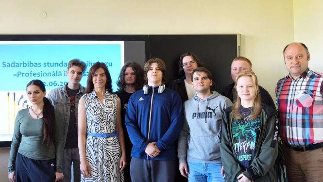 Kopbildē redzami izglītojamie un pedagogi pie interaktīvās tāfeles