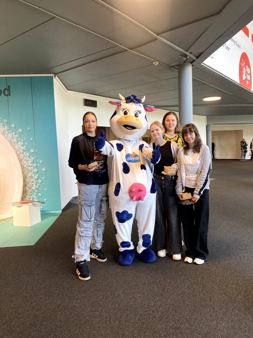 Tehnikuma izglītojamās kopā ar "Alma" talismanu izstādē "Riga Food 2026"