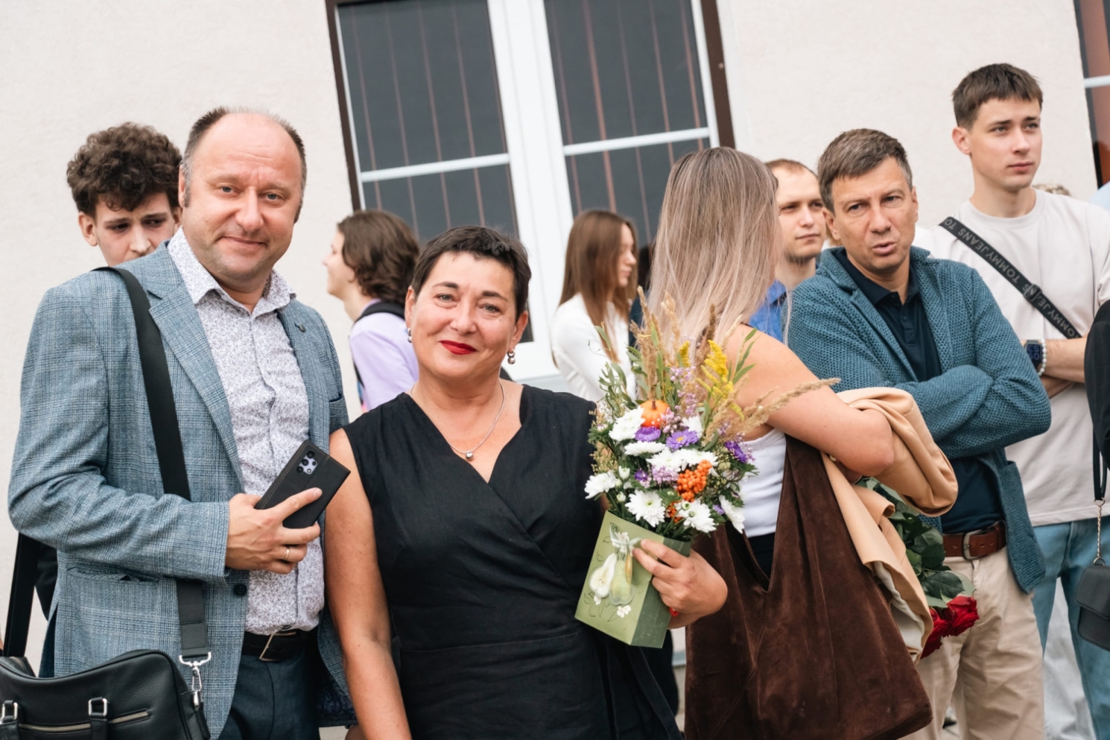 Skolotāju foto ar izglītojamajiem fonā