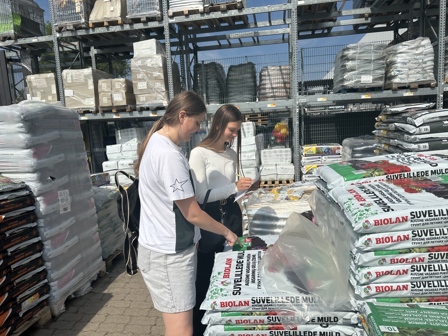 Divas izglītojamās pārbauda preču krājumus DEPO veikalā