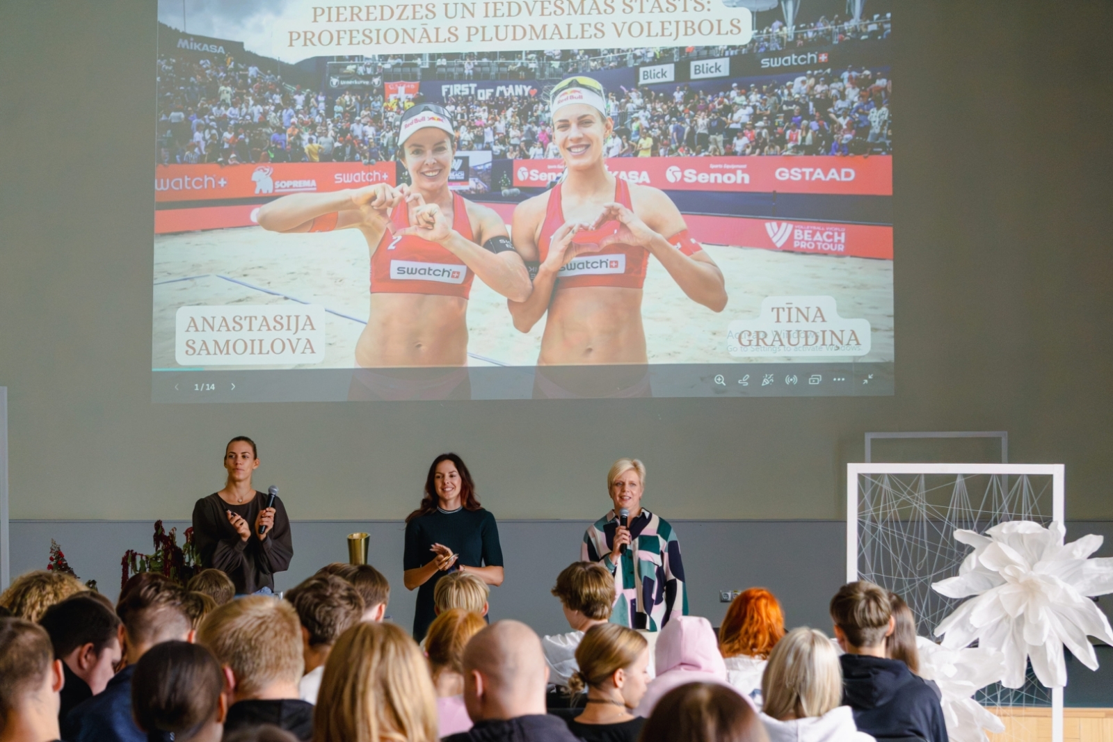 Sportistes kopā ar direktori uzstājas izglītojamo priekšā