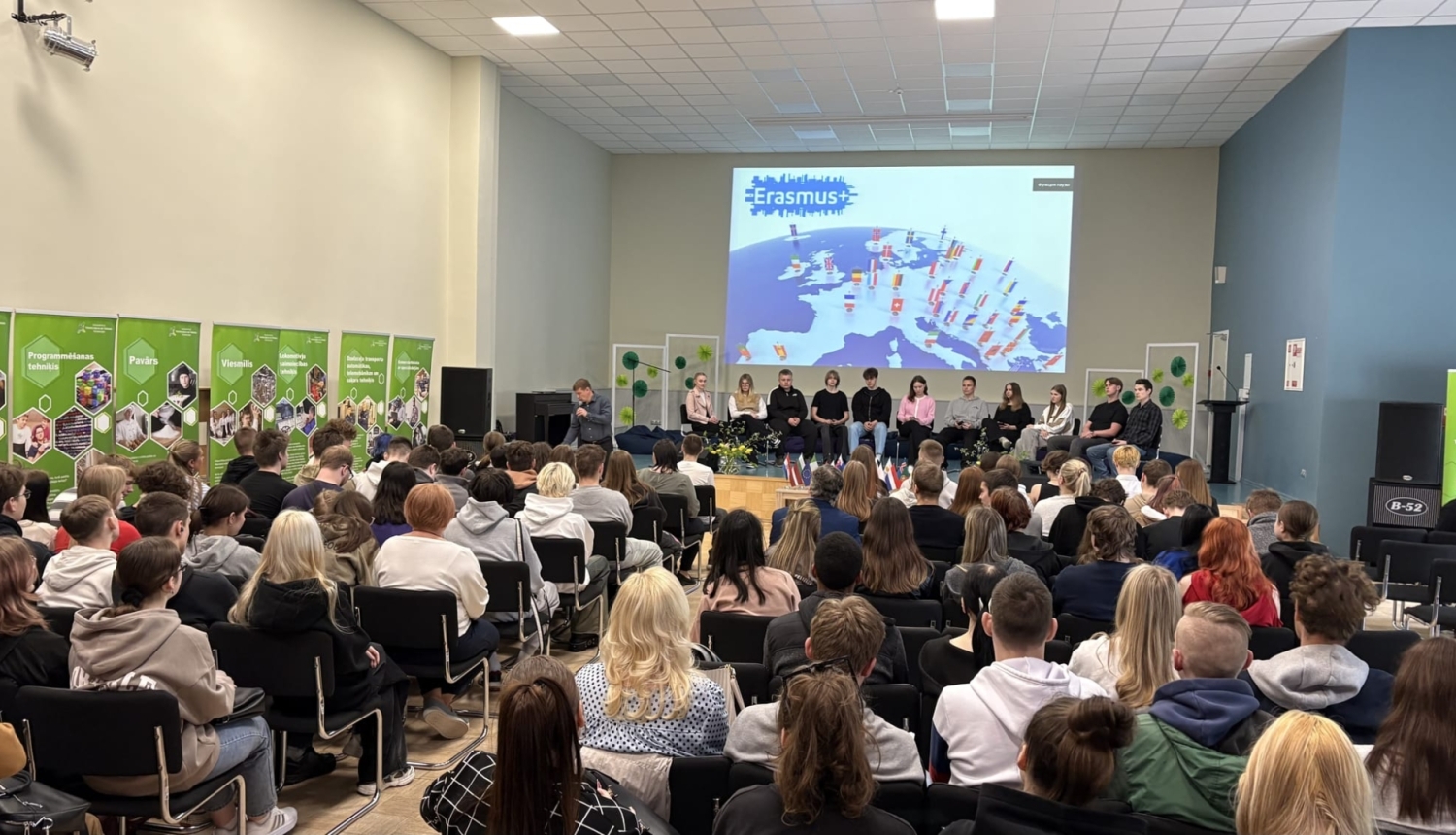Pilna aktu zāle klausās Erasmus+ mobilitāšu dalībnieku prezentāciju