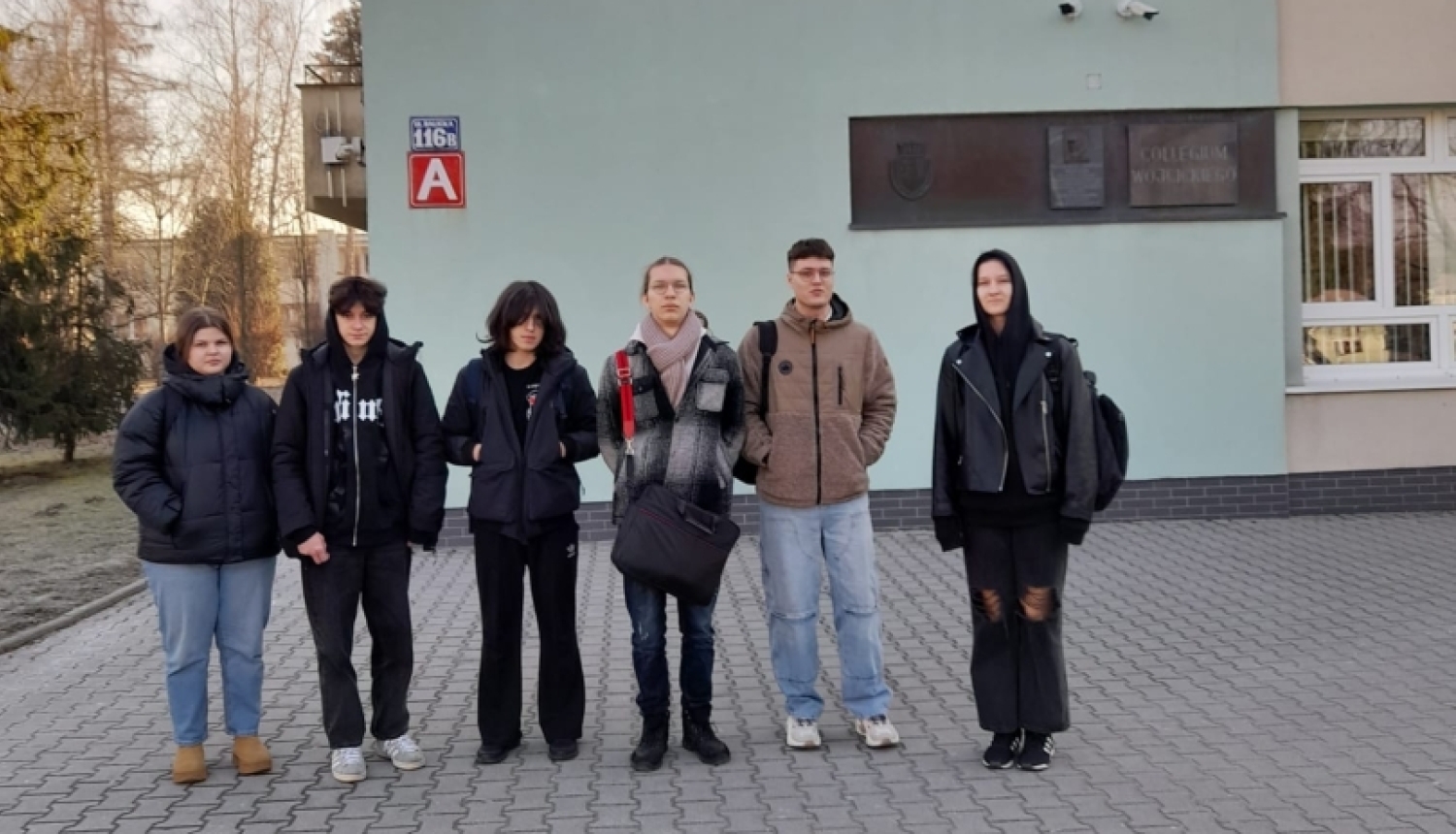     Seši izglītojamie stāv pie universitātes ēkas ieejas Krakovā