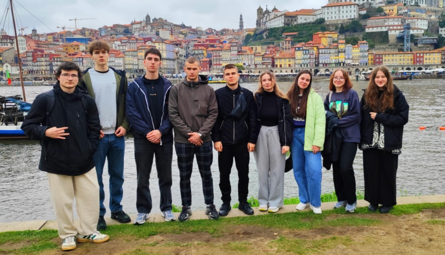     Izglītojamo grupa pozē Douru upes krastā ar Porto panorāmu fonā