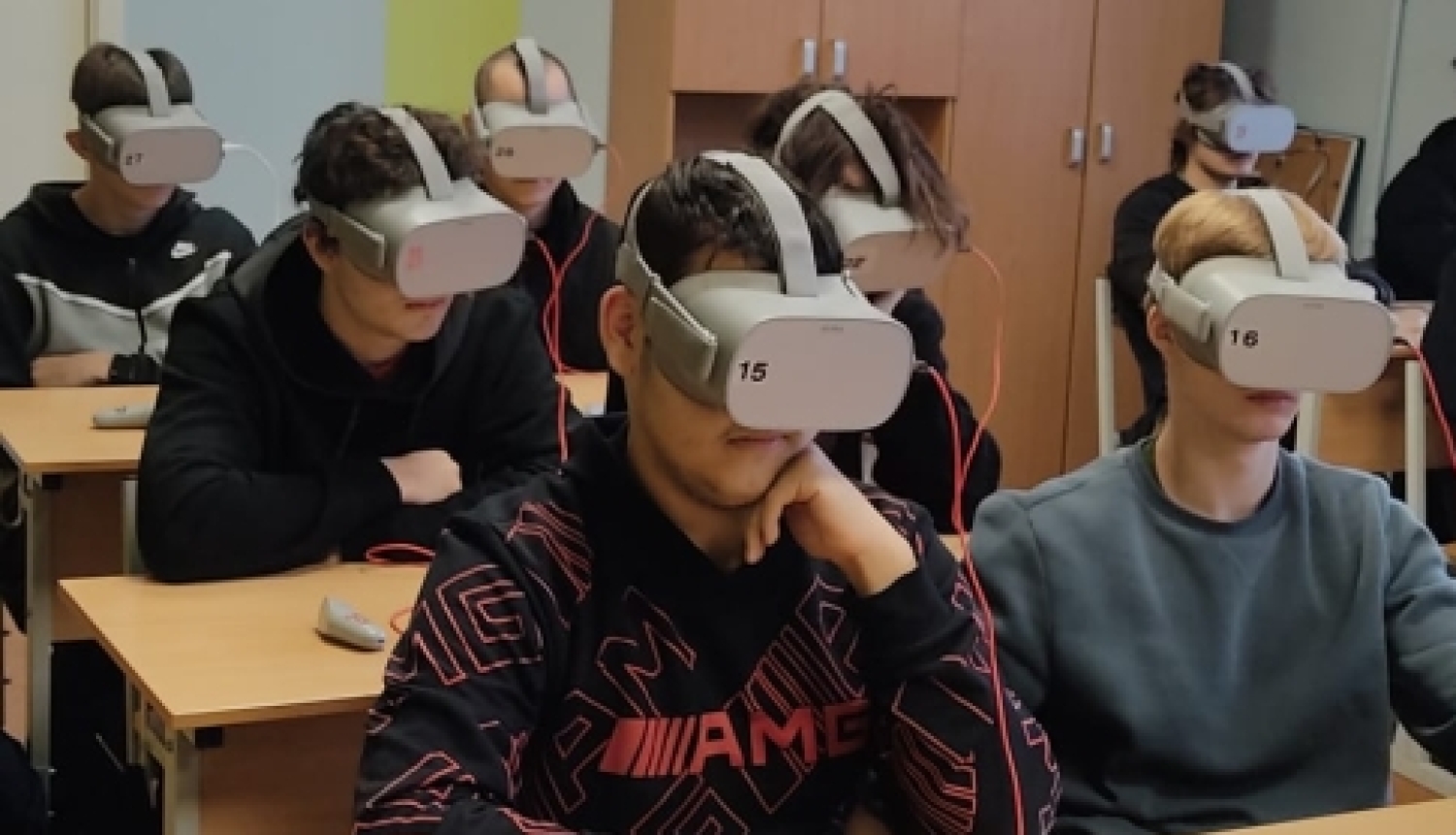 Izglītojamie sēž klasē ar VR brillēm