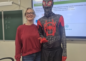 Pašvaldības pārstāvis cilvēka zirnekļa kostīmā kopā ar pedagogu