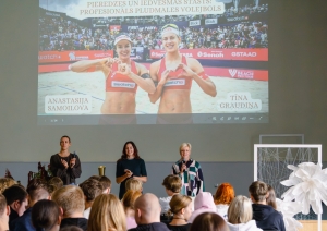 Sportistes kopā ar direktori uzstājas izglītojamo priekšā