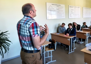Skolotājs vada stundu klases priekšā