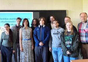 Kopbildē redzami izglītojamie un pedagogi pie interaktīvās tāfeles